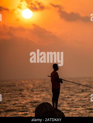 Ein Angler an einem Fischerhafen in Kerala Stockfoto