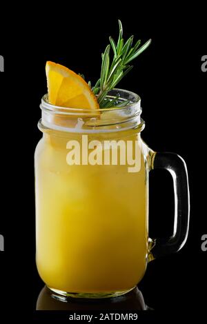 Becher mit Orangen- und Zitronencocktail isoliert auf schwarzem Hintergrund Stockfoto