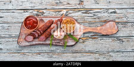 Wurst Paperoni. Salami mit Paprika. Auf weißem Holzhintergrund. Draufsicht. Freier Speicherplatz für Ihren Text. Stockfoto
