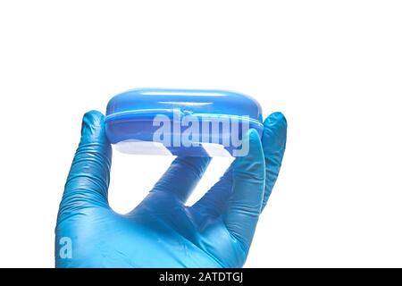 Die Hand des Stomatologen hält einen blauen Behälter für den benutzerdefinierten Zahntablett Stockfoto