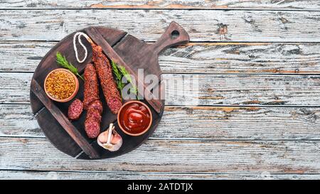 Wurst Paperoni. Salami mit Paprika. Auf weißem Holzhintergrund. Draufsicht. Freier Speicherplatz für Ihren Text. Stockfoto