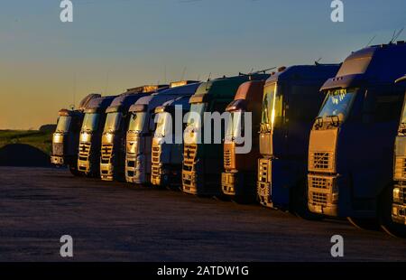 Mehrere Lastwagen parken auf einem großen Parkplatz. Stockfoto