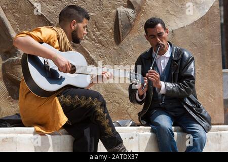 In Algier herumsitzen. Algerien hat eine hohe Arbeitslosigkeit, so dass viele Männer sitzen und Musik spielen oder sich unterhalten, während die Stunden weg sind. Algier. Stockfoto