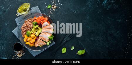 Schüssel Buddha. Buchweizen, Kürbis, Hühnerfilet, Avocado, Karotten. Auf schwarzem Hintergrund. Draufsicht. Freier Speicherplatz für Ihren Text. Stockfoto