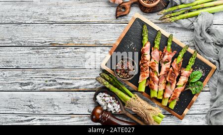 Spargel mit Speck und Gewürzen gebacken. Gesunde Ernährung. Draufsicht. Freier Speicherplatz für Ihren Text. Stockfoto