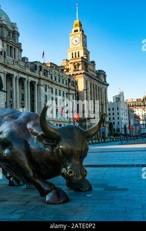 Arturo Di Modica's Shanghai Bull mit dem historischen Zollhaus und den ehemaligen Gebäuden der Hong Kong and Shanghai Banking Corporation im Hintergrund. Stockfoto