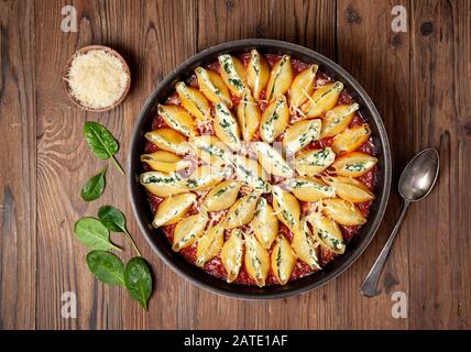 Gefüllte Nudelschalen mit Spinat und Ricotta auf einem alten Holzhintergrund. Blick von oben. Stockfoto