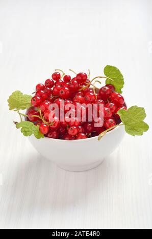 Rote Johannisbeeren in Weiß Schüssel auf dem Tisch, vegetarische Kost Stockfoto