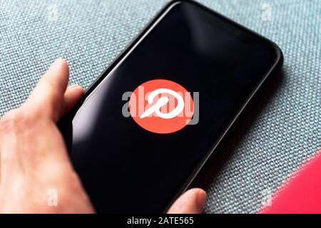 Junge Frau hält ein Smartphone mit Pinterest App auf dem Bildschirm. IPhone 11 mit einem Social-Media-App-Logo für interessante und außergewöhnliche Inhalte. Stockfoto