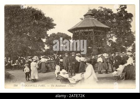 Originalpostkarte aus der Zeit Edwardians mit Besuchern, die einen Tag im Brockwell Park mit Bandstand und Zuschauern verbringen, Lambeth, London, um 1910 Stockfoto