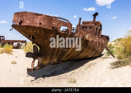 Isolierte zerstörte und verrostete Schiff auf dem Sand in Muynak Usbekistan Stockfoto