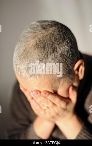 Frau, die ihr Gesicht bedeckt Stockfoto