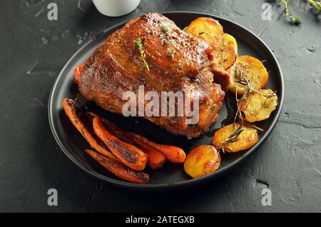 Gegrilltes Schweinefleisch, gebratenen Kartoffeln und Karotten auf einer Platte, Ansicht schließen Stockfoto