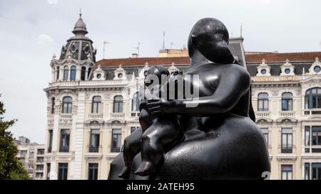 Bronzeplastik La Maternidad des Künstlers Fernando Botero auf der Plaza de La Escandalera mit Casa Conde Gebäude auf der Rückseite (Oviedo, Asturien, Spanien) Stockfoto