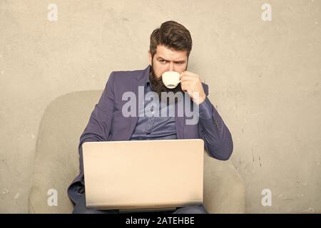 Moderne Geschäftsmann. Projekt Manager. Geschäftsmann Laptop. Mann trinken Kaffee im Büro. Reaktion auf geschäftliche E-Mails. Digitales Marketing. Im Internet surfen. Online kaufen. Geschäftliche Korrespondenz. Stockfoto