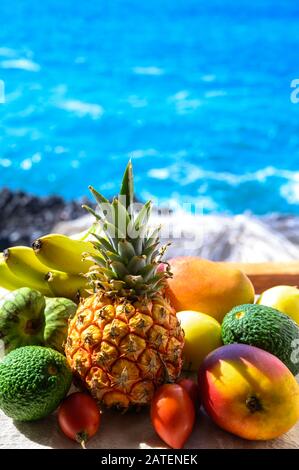 Tropische Früchte Sammlung, Custard Apple oder Grün reif cherymoia, Maracuja, Ananas, Mango, tamarillo, Avocado exotische Früchte auf blaues Meer hinterg Stockfoto