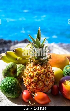 Tropische Früchte Sammlung, Custard Apple oder Grün reif cherymoia, Maracuja, Ananas, Mango, tamarillo, Avocado exotische Früchte auf blaues Meer hinterg Stockfoto