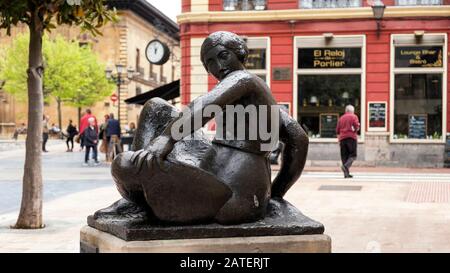 Bronzeplastik Mujer Sentada des Künstlers Manuel Martínez Hugué in der Calle San Francisco mit Plaza Porlier im Rücken (Oviedo, Asturien, Spanien) Stockfoto