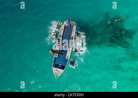 Luftbild der Tinnie Passage and Drop in Ghavutu Wharf, Ghavutu Island, Florida Islands und Sporttaucher im Boot, Solomon Islands, Solomon Sea Stockfoto