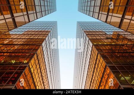 Goldenes Bürogebäude, blauer Himmel und Flugzeug - moderne Architektur im Geschäftsviertel Stockfoto