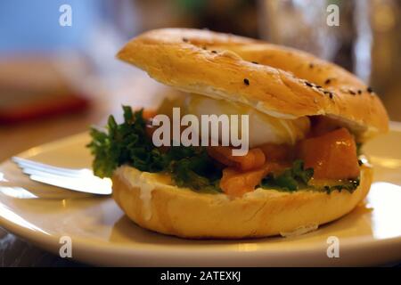 Frühstücksbagel mit Belägen und Kaffee auf dem Tisch Stockfoto