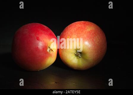 Zwei Äpfel auf Schwarz. Das Konzept der Ernährung Lebensmittel, Gesundheit. Stockfoto