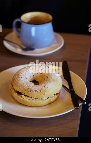 Frühstücksbagel mit Belägen und Kaffee auf dem Tisch Stockfoto
