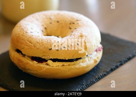 Frühstücksbagel mit Belägen und Kaffee auf dem Tisch Stockfoto