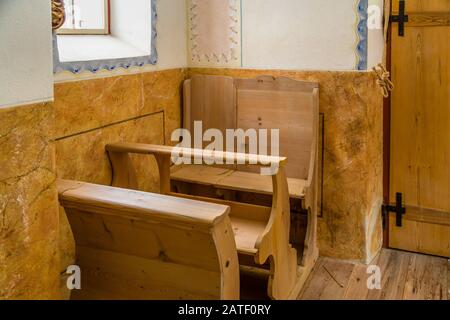 Badia (BZ), 10. februar 2019: Licht ist aufklärende Holzkneeler in der Kirche Stockfoto