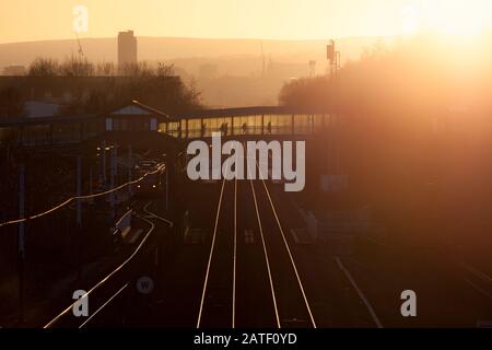 Sheffield Supertram 105 im Meadowhall Interchange Station, Sheffield mit Passagiersilhouetten gegen die Setzsumme Stockfoto