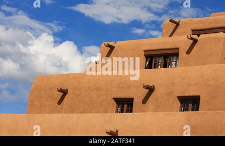 pueblo-adobe-Stuck gestuftes Gebäude. Konturierte pflasterarchitektur aus adobe mit blauem Himmel mit Holzvigas Stockfoto