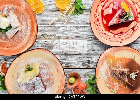 Auswahl an Frucht-Desserts und Backen auf einem Holztisch. Strudel, Cheesecake, Brownies, Eiscreme. Freier Speicherplatz für Ihren Text. Draufsicht. Stockfoto