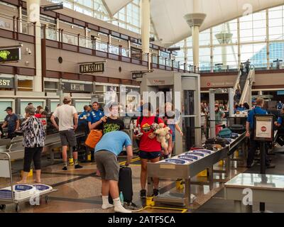 Reisende sammeln Habseligkeiten, nachdem sie den Sicherheitskontrollpunkt am Denver International Airport passiert haben Stockfoto