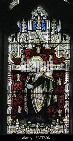 Detail eines Buntglasfensters der Kempe Studios, das die Kreuzigung Christi (Saint John) St Editha's Church, Church Eaton, Staffordshire darstellt Stockfoto