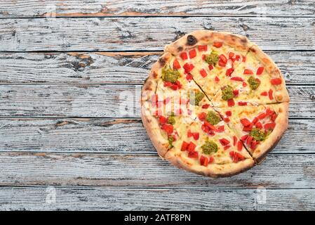 Pizza mit Pesto und Paprika. Italienische Küche. Auf Holzgrund. Freier Speicherplatz für Text. Draufsicht. Stockfoto