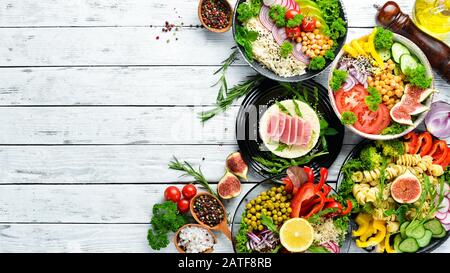 Satz Geschirr auf dem Tisch. Reis, Linsen, Kichererbsen, Fleisch und Fisch. Menü "Speisen". Freier Speicherplatz. Draufsicht. Stockfoto