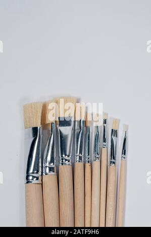 Neue Holz-Lackbürsten auf hellem Hintergrund. Stockfoto