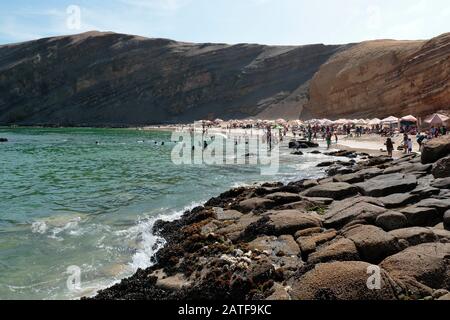 Playa La Mina, malerischer Blick auf den Strand neben den Badegästen im Sommer. Ica-Peru Stockfoto