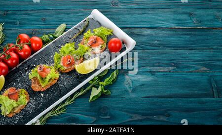 Sandwich mit Lachs und Salatblättern. Auf Holzgrund. Draufsicht. Kopierbereich. Stockfoto