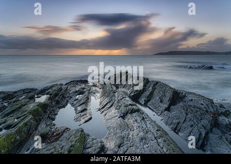 Milchmeere bei Sonnenuntergang auf den Felsen bei Bovisand in Devon Stockfoto