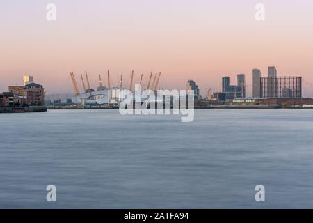 London und ein pinky/gelbes Leuchten am Himmel über der O2 Arena auf der North Greenwich Peninsula. Stockfoto