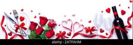 Valentines Day Dinner - White Table Setting Mit Geschenk Und Roten Rosen Stockfoto