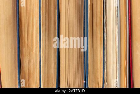 Alte und gut gebrauchte Hardback-Bücher oder Textbücher in einem Buchladen oder einer Bibliothek. Viele Bücher Stapeln Sich. Hardback-Bücher. Zurück zum Schulhintergrund mit Kopierbereich Stockfoto