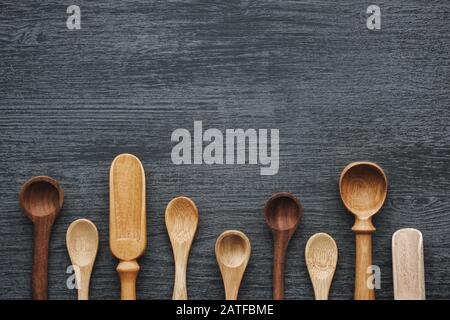 Leere Holzlöffel und Schaufeln auf grauem Holzkitchentisch. Draufsicht. Stockfoto