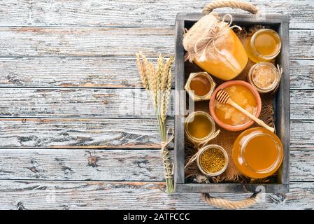 Legen Sie Honig in eine Holzkiste auf einem Holzhintergrund. Freier Speicherplatz für Text. Draufsicht. Stockfoto