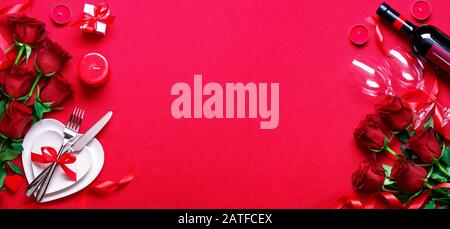 Abendessen Am Valentinstag - Rotes Romantisches Tischset Mit Weingeschenk Und Roten Rosen Stockfoto
