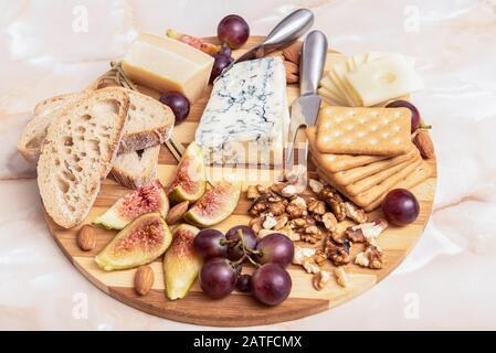 Käseplateau mit Nüssen, Trauben, Feigen, Mandeln und Brot Stockfoto