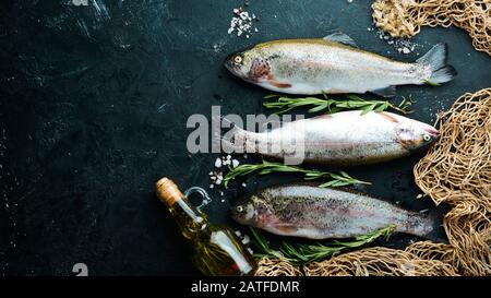 Rohe Fischforelle auf schwarzem Grund. Draufsicht. Freier Speicherplatz für Ihren Text. Stockfoto