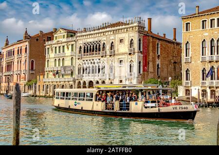 Eine Route 2 Vaporetto, die mit Passagieren besetzt ist, vorbei an der Ca' d'Oro, einem gotischen Palast am Canal Grande, im Viertel Cannaregio, Venedig Italien Stockfoto