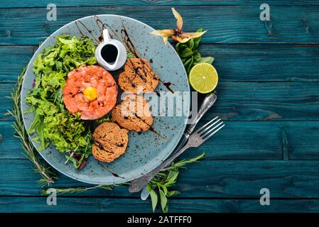 Tatar mit Lachs und Avocado. Auf Holzgrund. Draufsicht. Kopierbereich Stockfoto